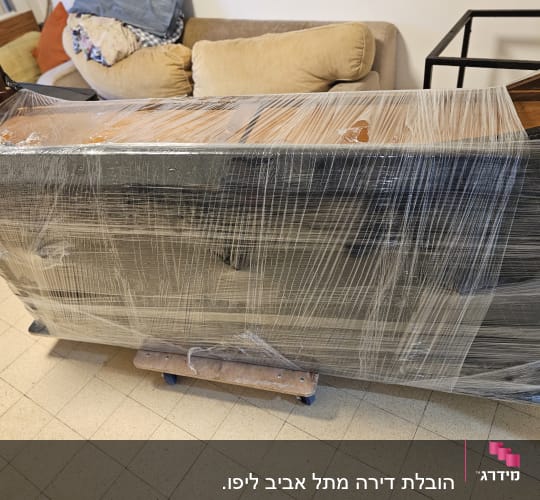 רהיט עטוף בניילון נצמד על גלגלים להובלה